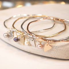 Personalised bridesmaid presents bangles with heart charms.