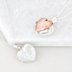 Close up of silver and rose gold hidden message heart locket