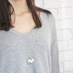 Silver hammered heart pendant with personalised heart charm worn by model