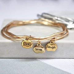 Close up of gold Live Love Laugh Mantra Bangles set