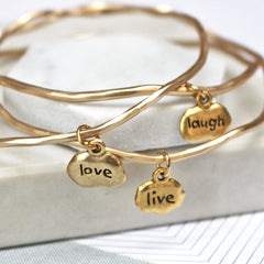 Close up of gold Live Love Laugh Mantra Bangles set