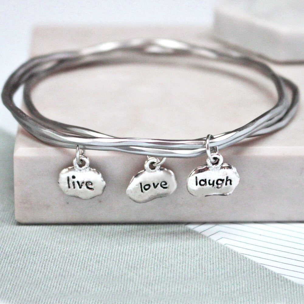 Close up of silver Live Love Laugh Mantra Bangles set