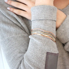 Model wearing mixed metal stacking bangle set