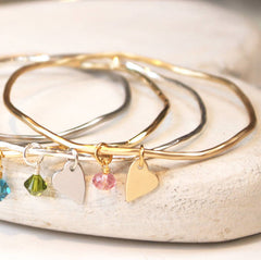 Close up of personalised bridesmaid gifts heart bangles with crystals.