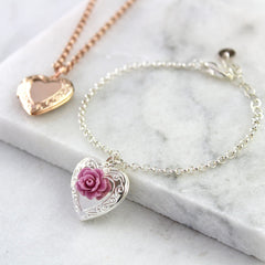 Silver vintage heart locket bracelet with mauve rose and rose gold vintage heart necklace in background