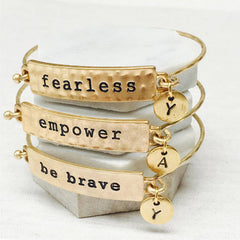 Stacking gold mantra bracelets; fearless, empower and be brave