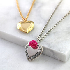 Vintage heart locket in antique silver and gold in background