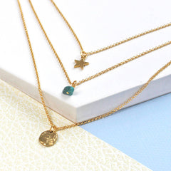 Close up of Birthstone Layered Charm Necklace gold