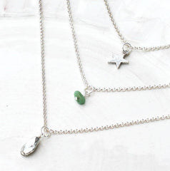 Close up of sterling silver Birthstone Layered Charm Necklace