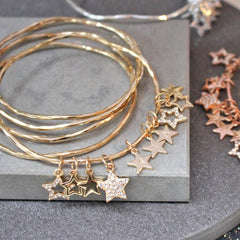 Close up of personalised diamante star bangles in gold