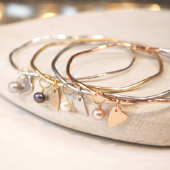 Personalised bridesmaid presents bangles with heart charms. 