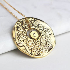 Close up of lucky hamsa hand necklace in gold with hand stamped personalisation
