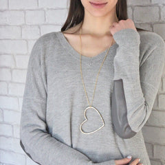 Gorgeous large heart necklace hanging from long chain in gold worn by model