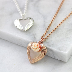 Close up of rose gold vintage heart locket with peachy pink rose