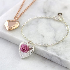 Silver vintage heart locket bracelet with mauve rose and rose gold vintage heart necklace in background