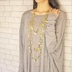 Set of three chains of gold necklaces on model
